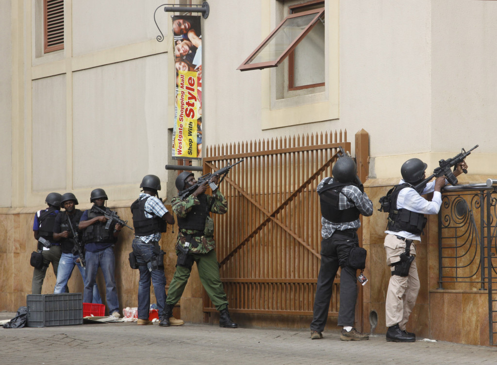 FILE - In this Saturday, Sept. 21, 2013 file photo, armed special forces aim their weapons at the Westgate Mall in Nairobi, Kenya following an attack by armed Islamic extremist group al-Shabab. Undercover police officers armed only with pistols and walkie-talkies, as well as unarmed mall security guards helped save countless lives in the initial minutes and hours of the attack - heroics those they brought to safety say have gotten too little attention. (AP Photo/Khalil Senosi, File)